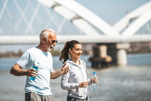 Older man exercising with younger health coach