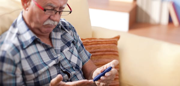 A man sitting on a couch with a cell phone.