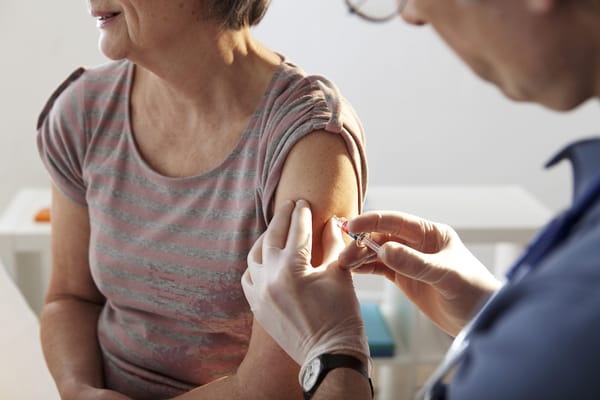 A woman is getting a vaccine from a doctor.