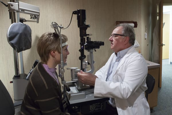 A young man is being examined by an optometrist.