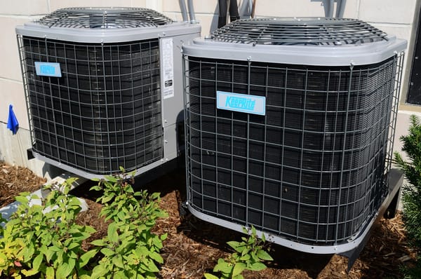 Two air conditioners in front of a building.